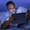 Blue light skincare HEV, man browsing tablet at night