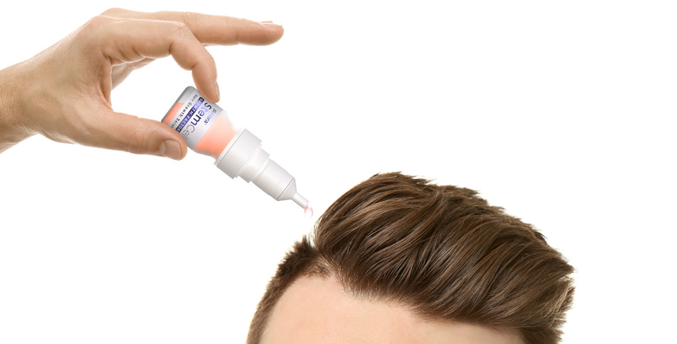 Applying hair growth serum to man's scalp
